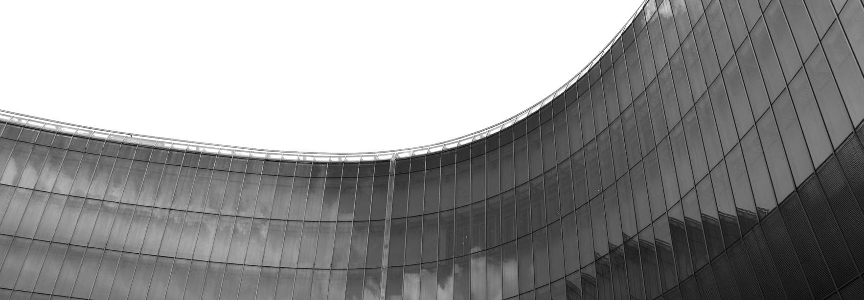 Edificio moderno con fachada curva y reflectante en blanco y negro.