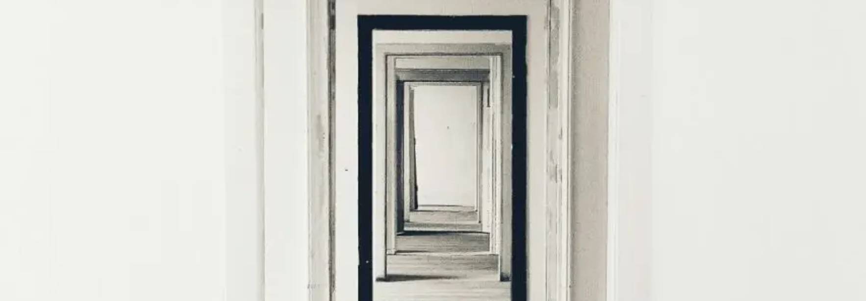 La imagen muestra una serie de puertas alineadas en un pasillo vacío y luminoso.