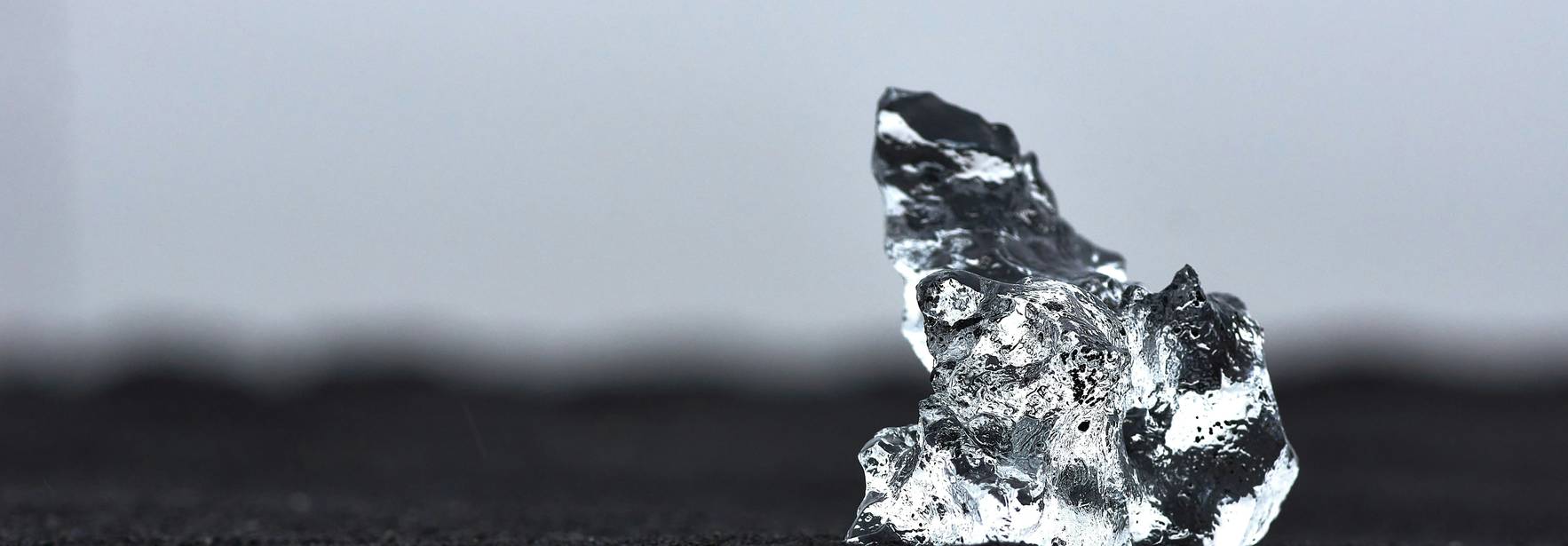 Una pieza de hielo brillante sobre una superficie oscura.