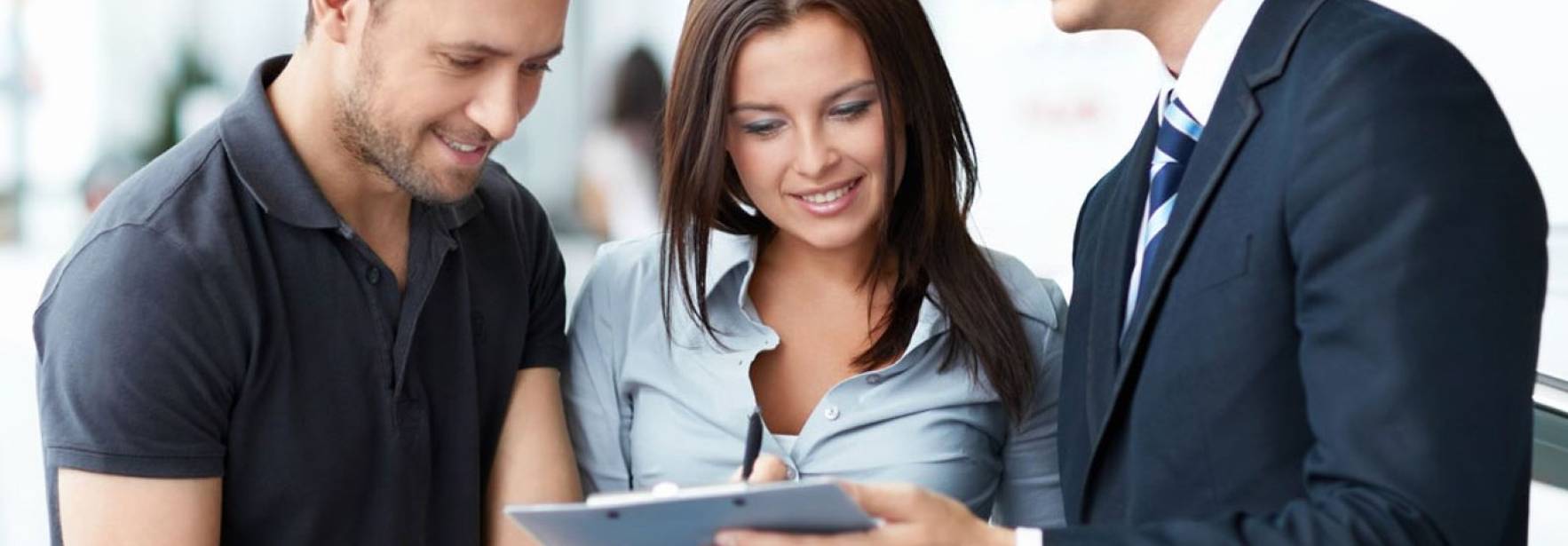 Un grupo de tres personas, dos hombres y una mujer, revisando documentos en un entorno profesional.