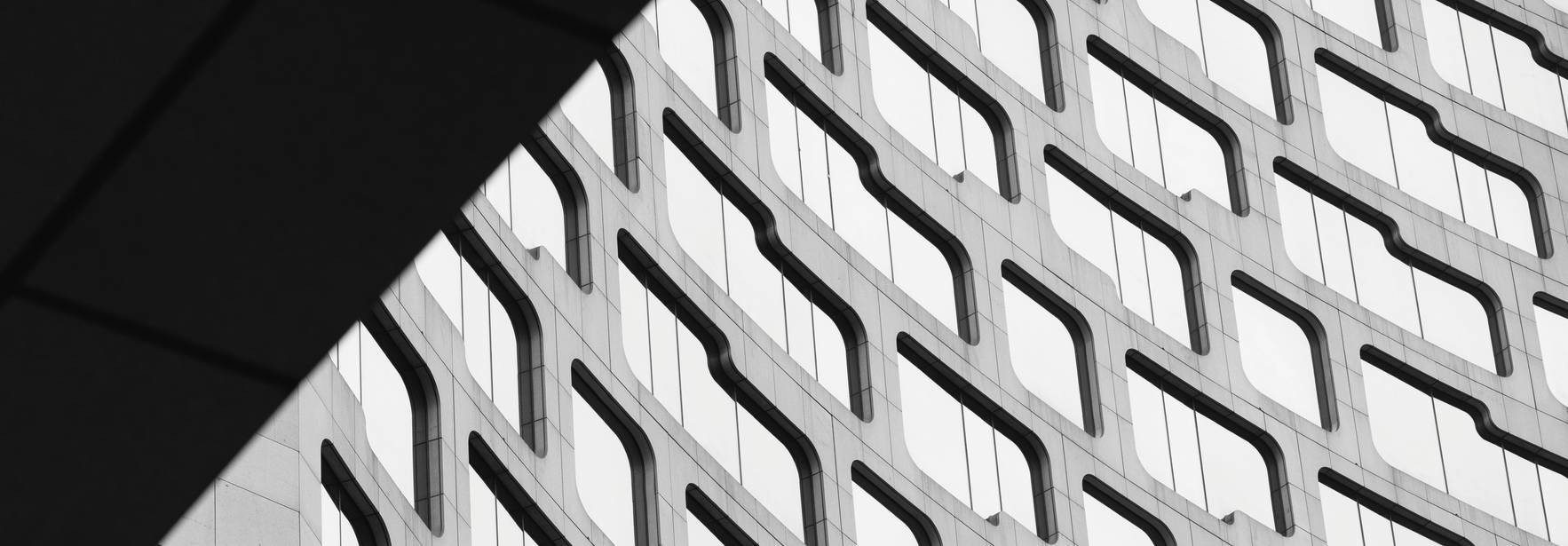 Una imagen en blanco y negro que muestra la estructura de un edificio moderno con un diseño arquitectónico curvilíneo.