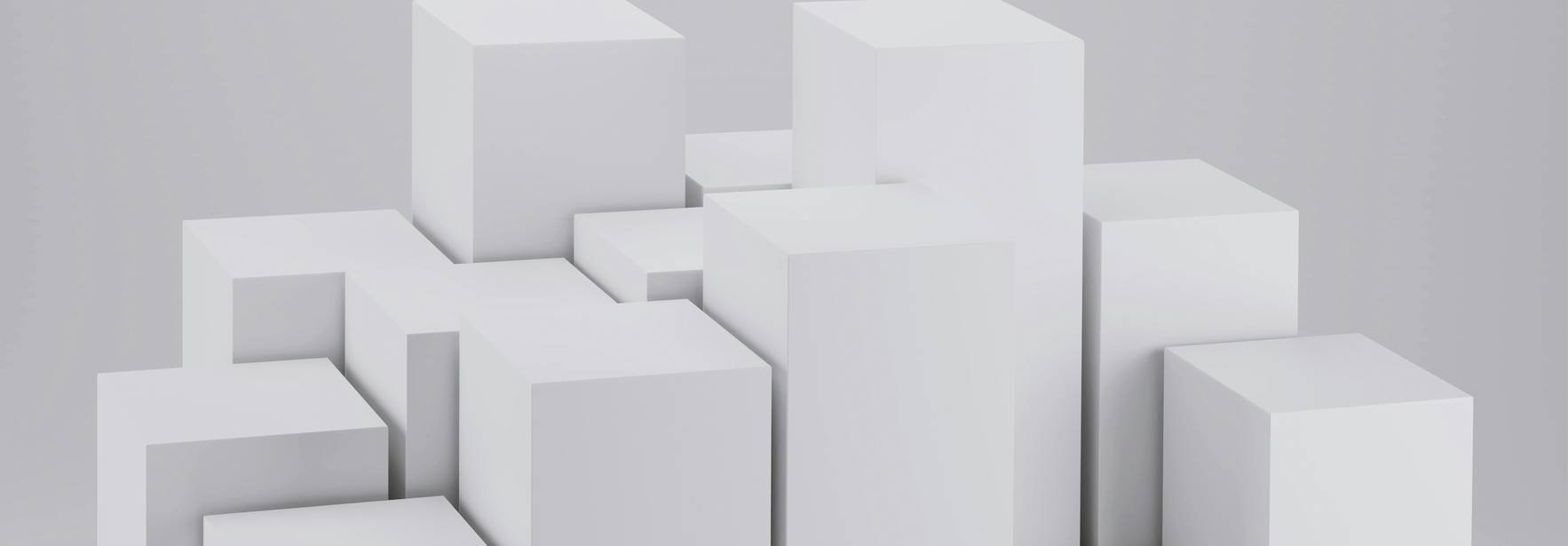 La imagen muestra una composición de bloques blancos de diferentes tamaños dispuestos de manera abstracta sobre un fondo gris claro.
