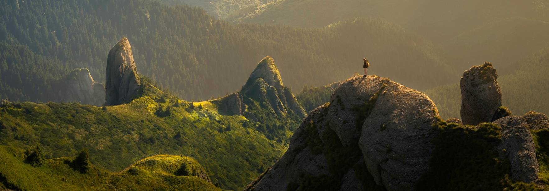 Una vista panorámica de un paisaje montañoso con un cielo iluminado por la luz del sol.