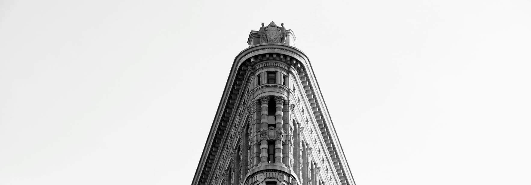 Edificio con forma distintiva y esquina afilada en blanco y negro.