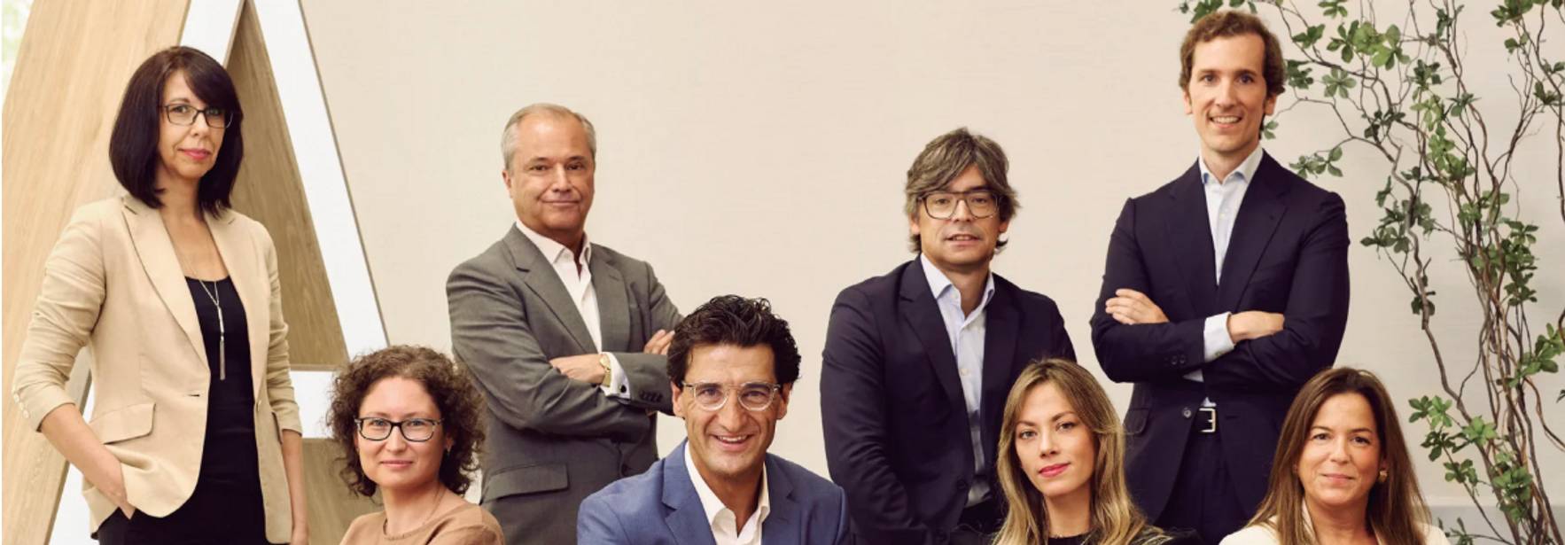 Un grupo de ocho personas posando en un ambiente moderno y profesional.