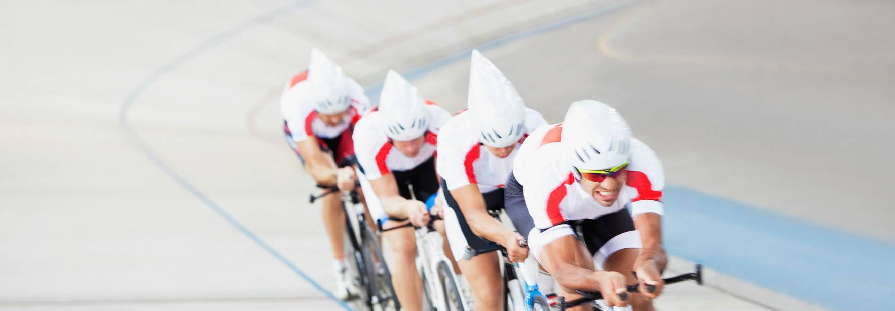 Un grupo de ciclistas compitiendo en una pista de velódromo.
