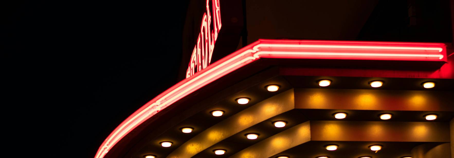 Una marquesina iluminada de un cine en la noche.