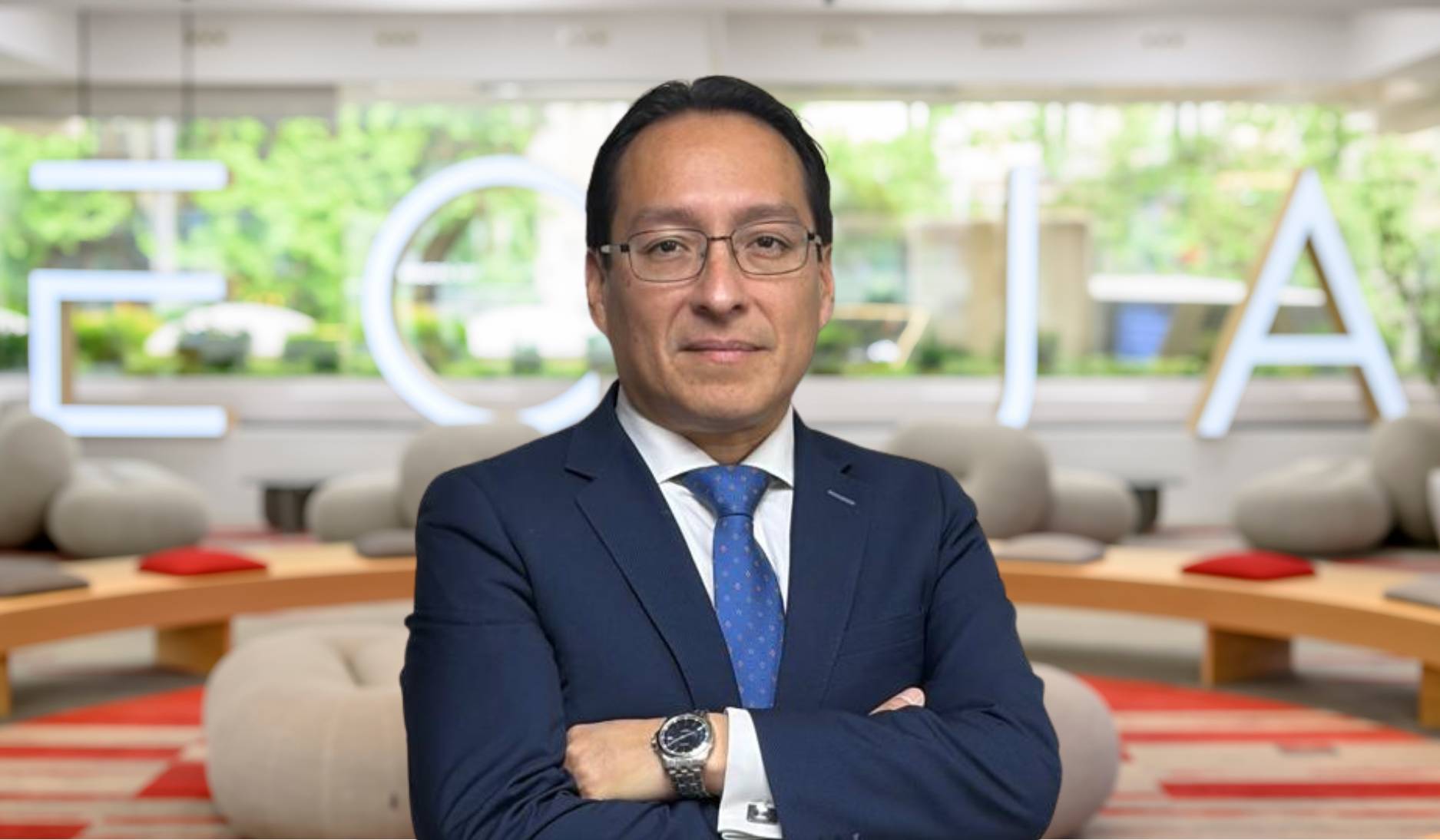 Un hombre de negocios posando con un fondo moderno de oficina.