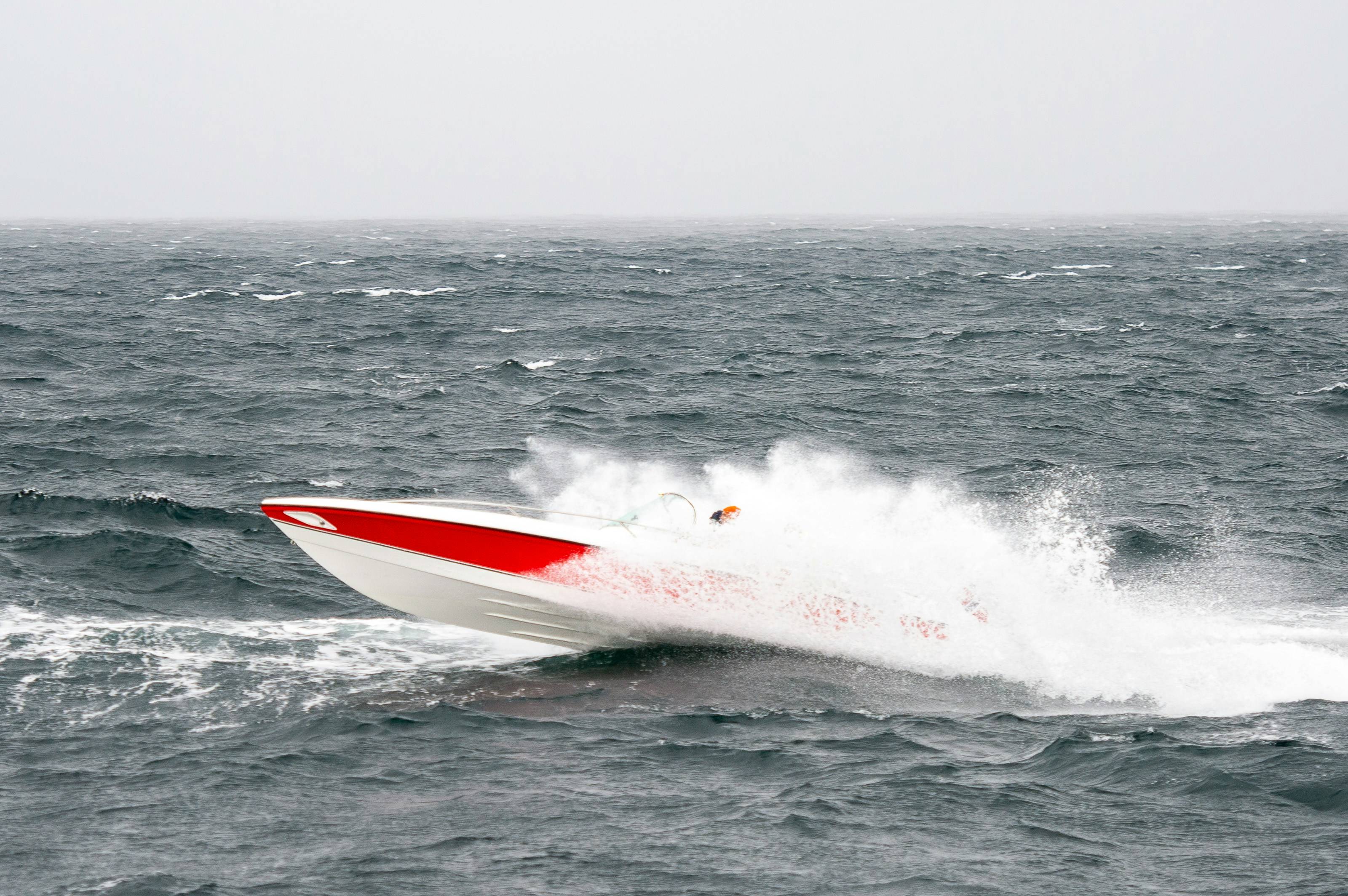 Un barco de motor surca las aguas agitadas del mar produciendo grandes olas.