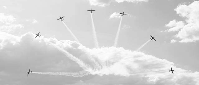 Un grupo de aviones realiza una exhibición acrobática en el cielo nublado.