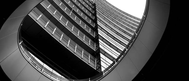 La imagen muestra un edificio moderno visto desde un ángulo inusual, en un contraste de blanco y negro.