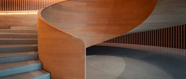 Una elegante escalera de madera que se enrolla suavemente en un interior moderno.