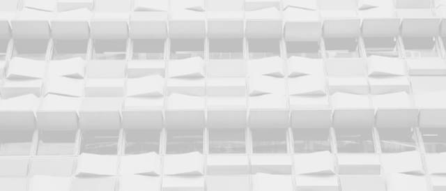 Una fachada moderna con paneles blancos que presentan una textura ondulada.