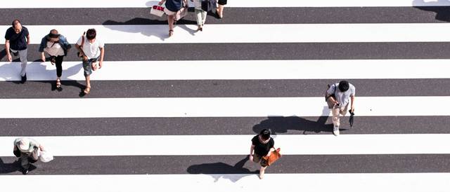 Una vista aérea de un cruce peatonal con muchas personas caminando.
