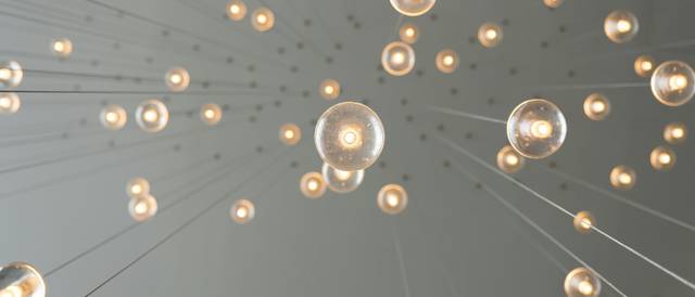 La imagen muestra una serie de luces colgantes desde un techo, creando un efecto visual fascinante.