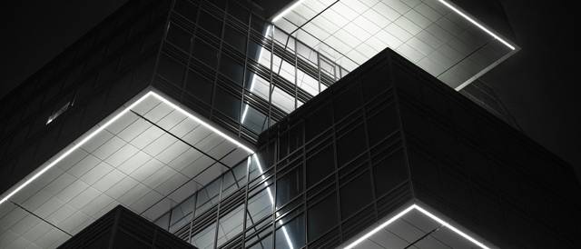 Una moderna estructura arquitectónica iluminada con un diseño geométrico y líneas rectas.