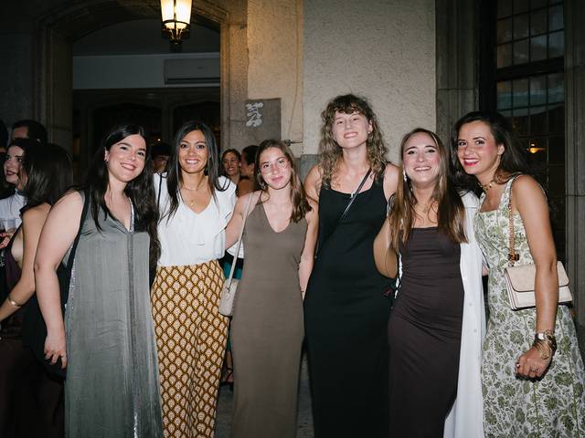 Un grupo de seis mujeres posando juntas en un evento social elegante.