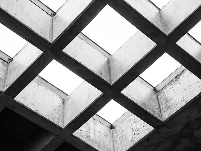 La imagen muestra un techo de hormigón con claraboyas en un patrón geométrico en blanco y negro.