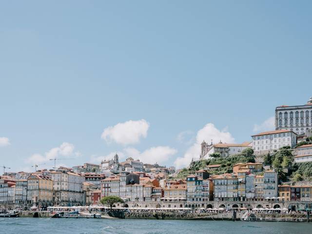 Una vista panorámica de la ciudad con edificios coloridos a la orilla del agua bajo un cielo despejado.