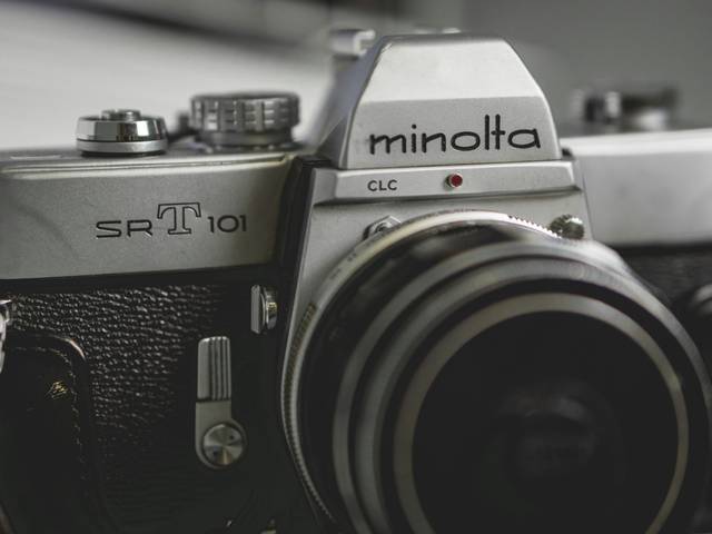Una cámara analógica Minolta SR-T 101 con un diseño vintage y un objetivo grande.