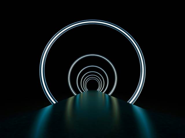 Un pasillo oscuro con anillos de luz que crean una atmósfera futurista.