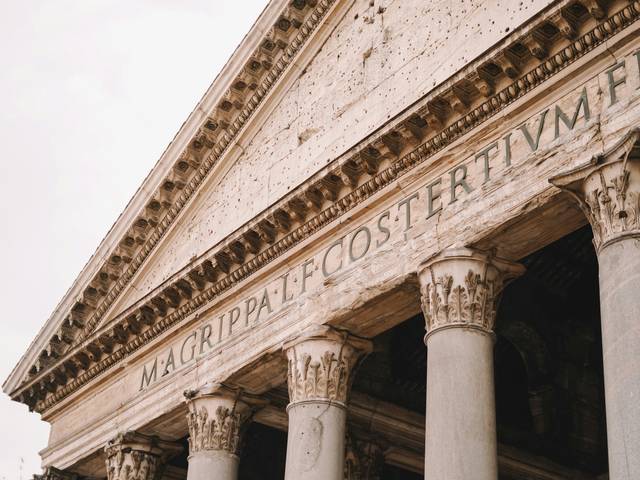 Primer plano de la fachada del Panteón de Roma, destacando sus columnas y inscripción.