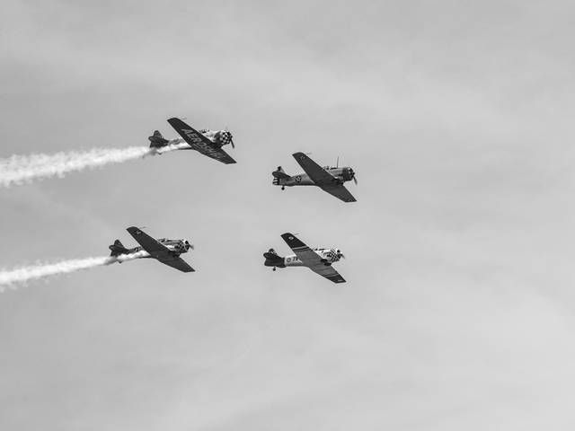 Cuatro aviones realizan formaciones en el cielo mientras dejan estelas de humo.