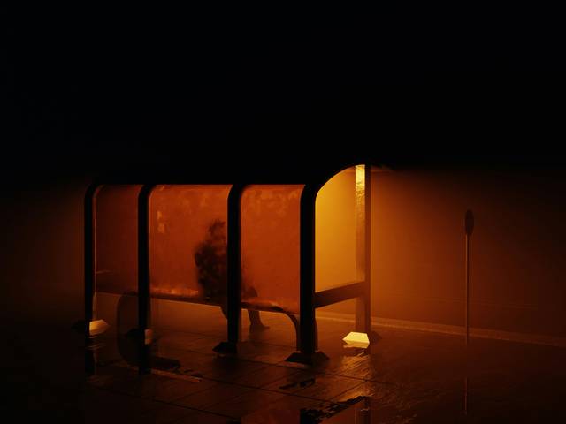 Una persona espera en una parada de autobús iluminada en medio de la niebla oscura.