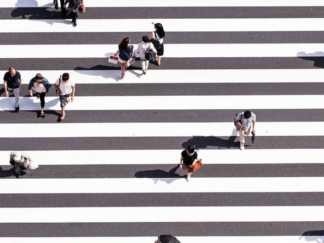 Una vista aérea de un cruce peatonal con muchas personas caminando.