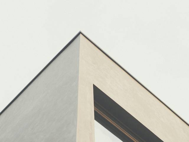 La imagen muestra la punta de un edificio moderno con un diseño minimalista.