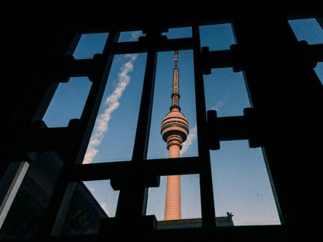 Vista de una torre desde una ventana con un cielo despejado.