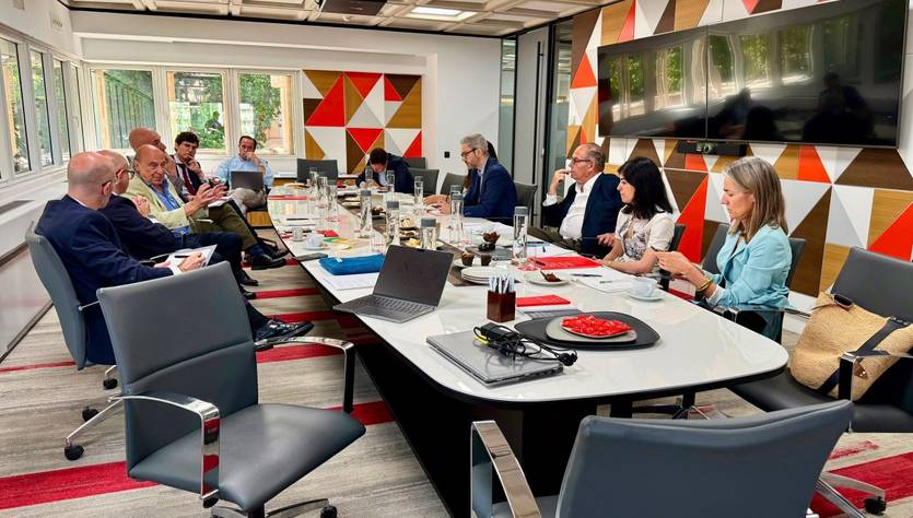 Una reunión de varias personas en una sala de conferencias con una decoración colorida.