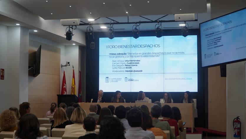 Imagen de un foro sobre bienestar en el que varias personas están sentadas en un panel mientras el público observa.