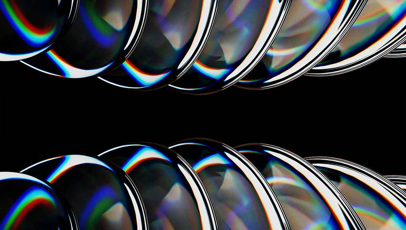 La imagen muestra una serie de lentes brillantes dispuestos en una línea sobre un fondo negro.