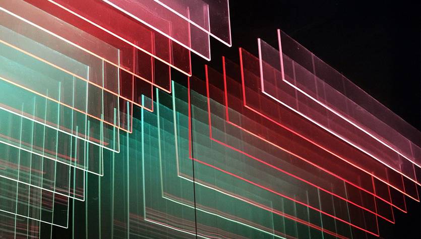 La imagen muestra una serie de líneas en capas con tonos de rojo, verde y azul que crean un efecto visual dinámico.