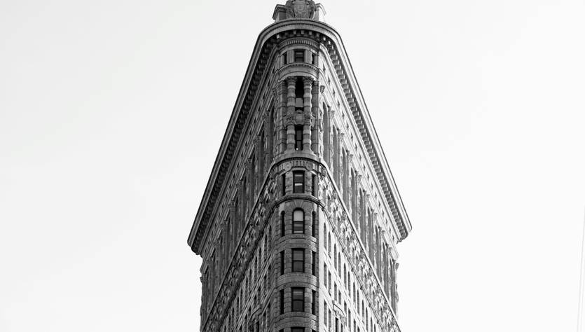 Edificio con forma distintiva y esquina afilada en blanco y negro.