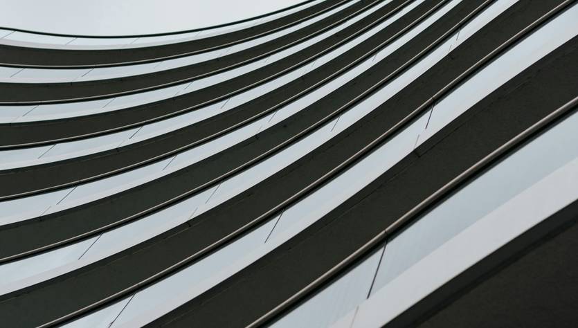 Una imagen que muestra la fachada de un edificio moderno con líneas curvas y ventanas de cristal.