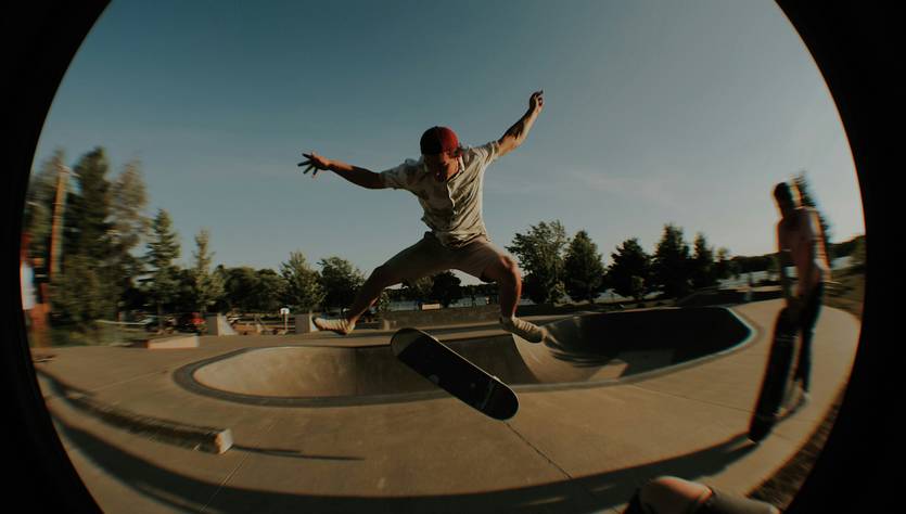Un skater realiza un salto acrobático sobre un skate en un parque.