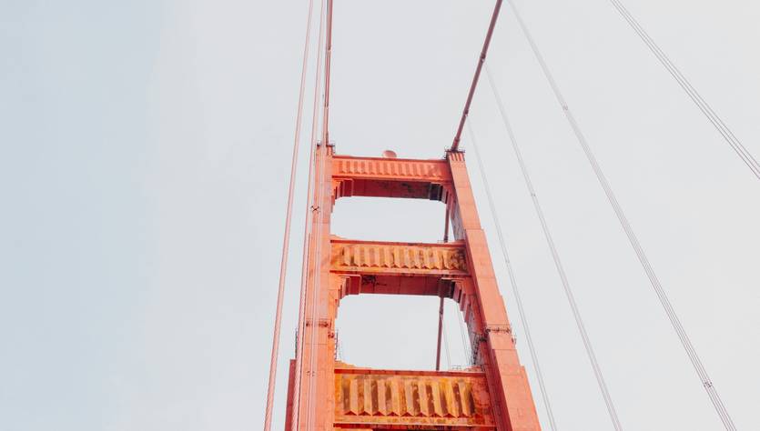 Una vista del puente dorado desde abajo en un día despejado.