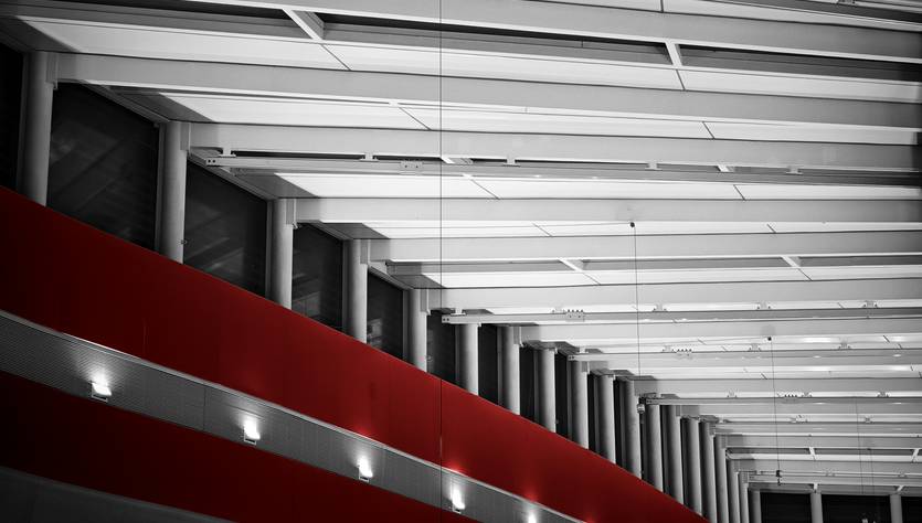 La imagen muestra el interior de un edificio con un diseño arquitectónico moderno y luces en la pared.