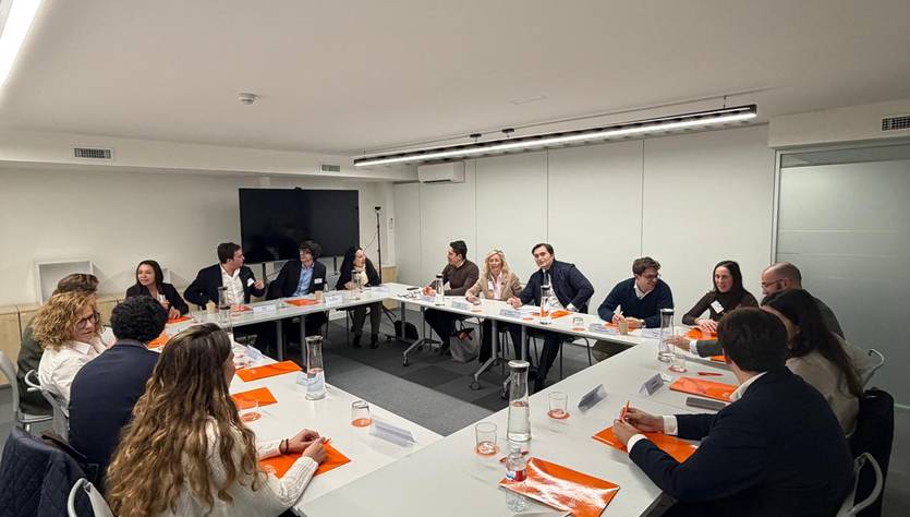 Reunión de un grupo de personas alrededor de una mesa en una sala de conferencias.