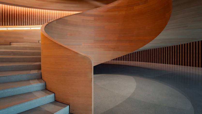 Una elegante escalera de madera que se enrolla suavemente en un interior moderno.