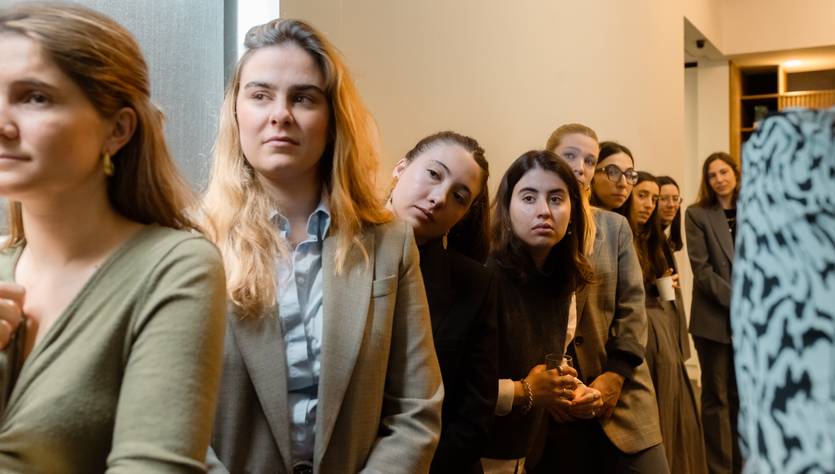 Un grupo de mujeres jóvenes está haciendo fila en un espacio moderno y bien iluminado.