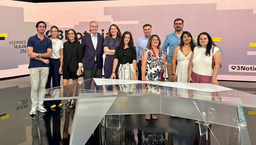 Un grupo de personas posando juntas en un estudio de televisión.