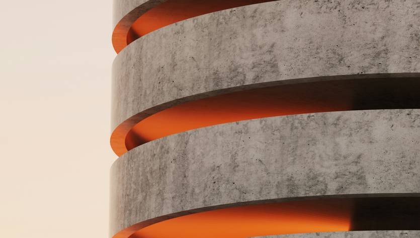 Una estructura arquitectónica de concreto con franjas iluminadas de color naranja.