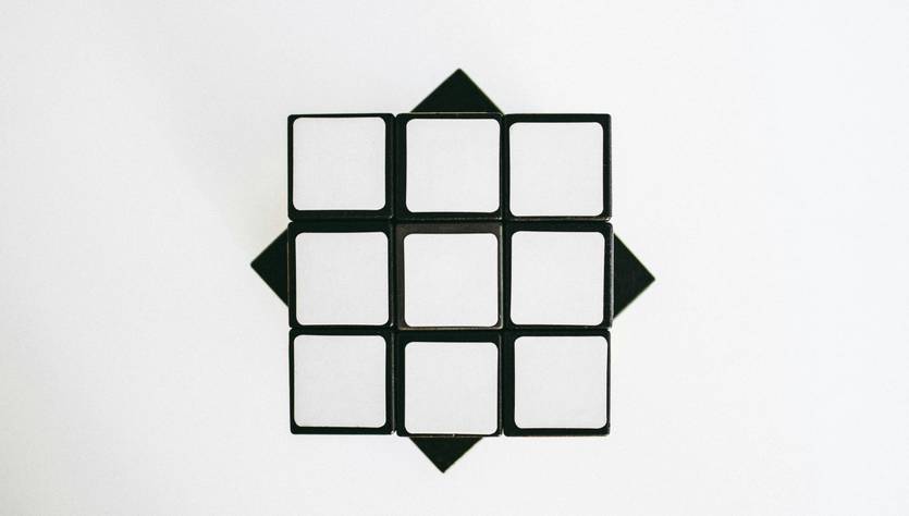 Una vista superior de un cubo de Rubik vacío y desarmado sobre un fondo blanco.