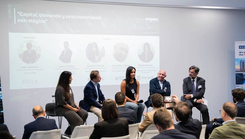 Un panel de discusión sobre 'Capital, demanda y posicionamiento estratégico' con varios ponentes en un evento empresarial.
