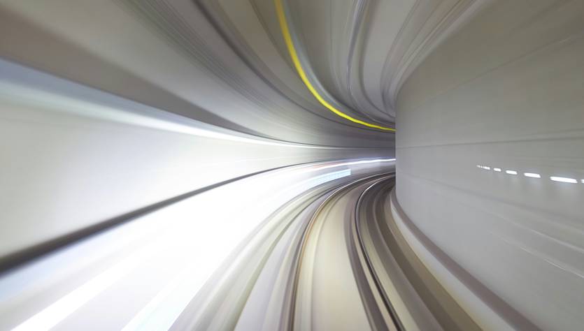 Una imagen que muestra un túnel en movimiento con líneas de luz que se distorsionan por la velocidad.