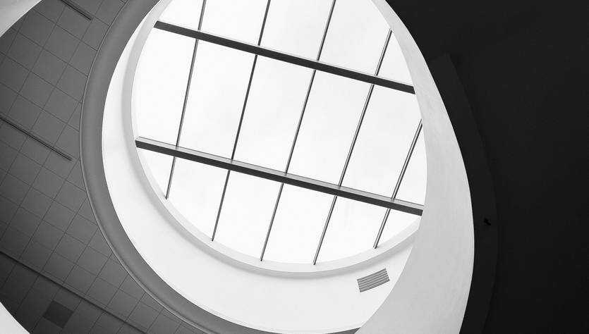 Vista en blanco y negro de una estructura arquitectónica en espiral con un techo de cristal.