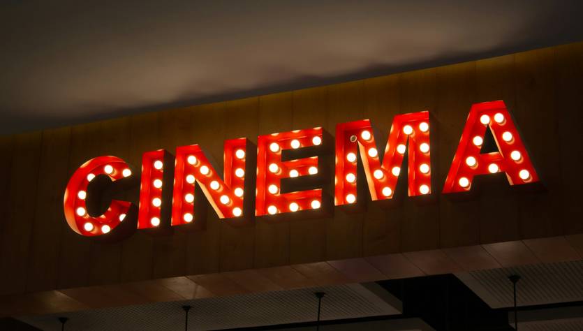 La imagen muestra un letrero luminoso que dice 'CINEMA'.